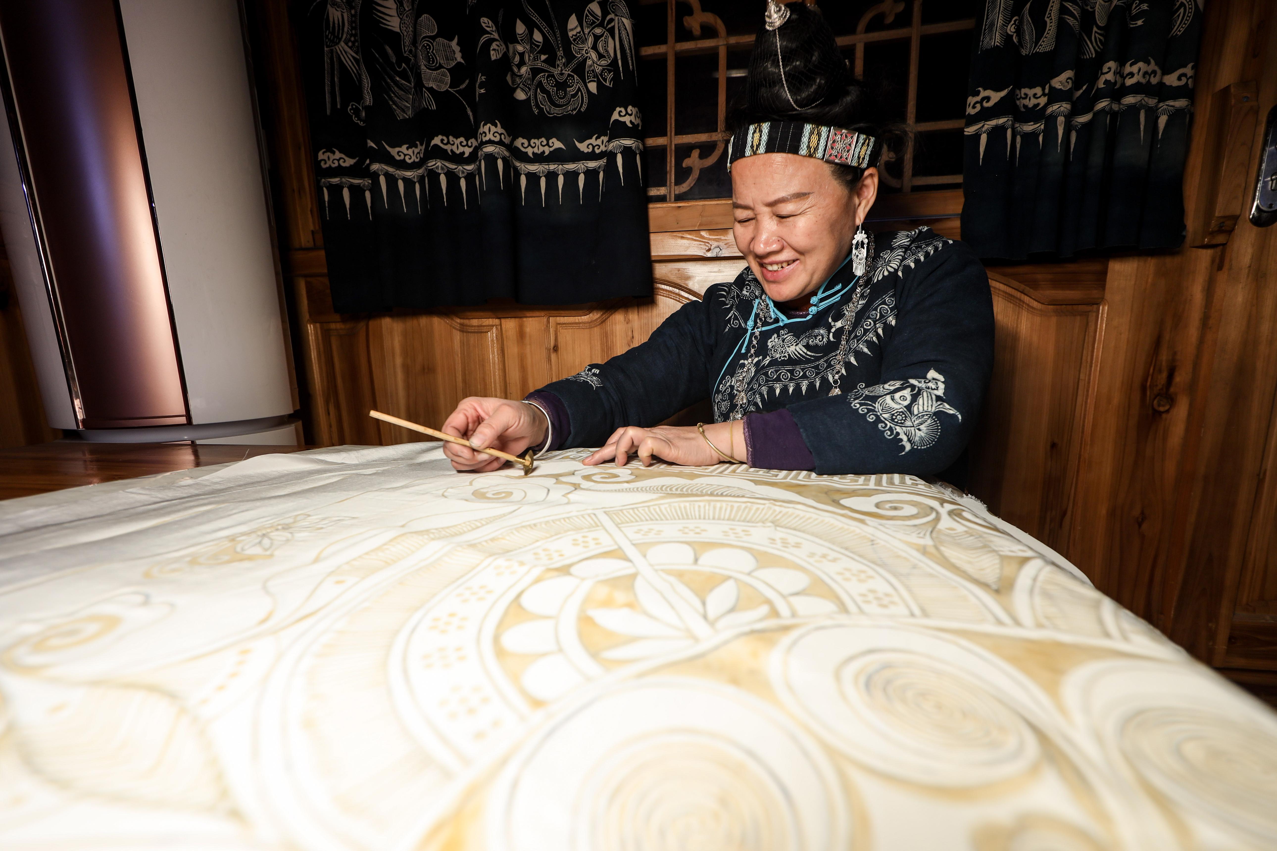 Artisan creating a traditional wax-resist textile by hand